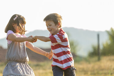 Glücklicher kleiner Junge und Mädchen spielen zusammen in der Natur - ZOCF000117