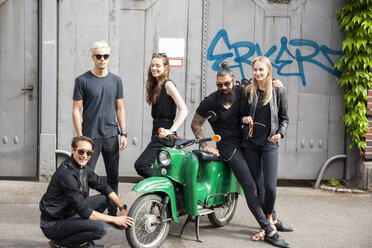 Group of five black dressed friends with green moped - CHAF001664