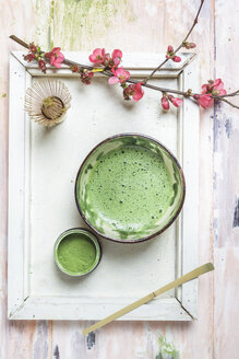 Matcha-Tee in Schale, mit Matcha-Pulver, Löffel und Chasen und rosa Blumen - SBDF002859