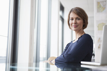 Portrait of confident businesswoman at office desk - RBF004423