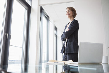 Confident businesswoman in office thinking - RBF004427