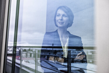 Geschäftsfrau schaut aus dem Fenster - RBF004438