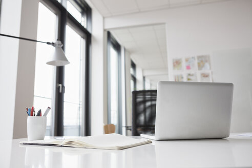 Laptop and notebook on office desk - RBF004453