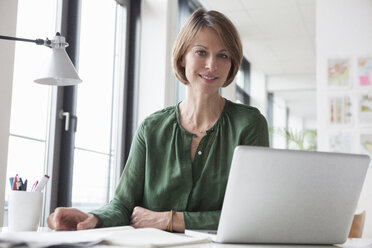 Portrait of confident businesswoman at office desk - RBF004454