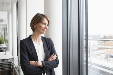 Businesswoman looking out of window - RBF004473