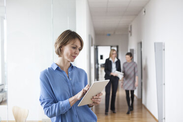 Geschäftsfrau mit digitalem Tablet auf dem Büroboden - RBF004501