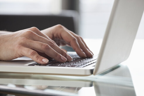 Nahaufnahme der Hände einer Frau, die einen Laptop benutzt - RBF004521