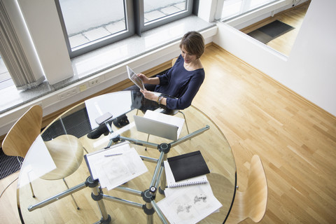 Geschäftsfrau mit digitalem Tablet und Laptop am Bürotisch, lizenzfreies Stockfoto