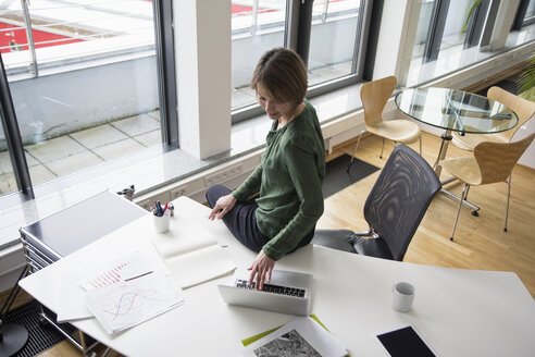 Geschäftsfrau mit Laptop am Bürotisch - RBF004532