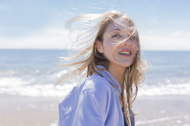 Portrait of smiling young woman with blowing hair at seaside - BOYF000290