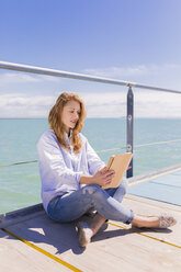 Portrait of young woman using digital tablet in front of the sea - BOYF000297