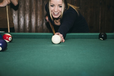 Frau spielt Pool-Billard in einer Bar, lächelnd - ABZF000382