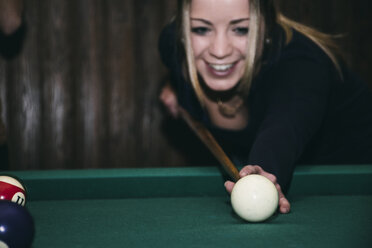 Frau spielt Pool-Billard in einer Bar, lächelnd - ABZF000383