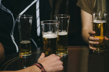 Group of people with glasses of beer on a table in a bar - ABZF000390