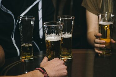 Gruppe von Menschen mit Biergläsern auf einem Tisch in einer Bar - ABZF000390