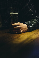 Hand of a man with a glass of beer in a bar - ABZF000396