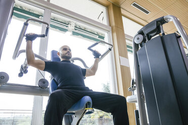 Mann beim Training mit einem Fitnessgerät - ABZF000433