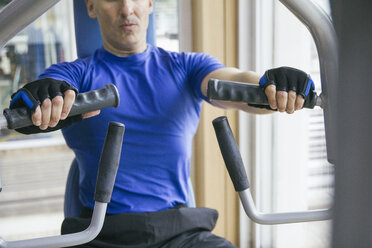 Mann macht Brustübungen an einem Fitnessgerät - ABZF000434
