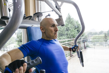 Man doing chest exercises with a fitness machine - ABZF000435