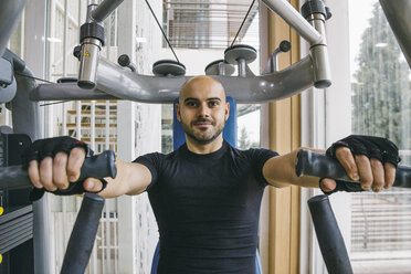 Man doing chest exercises with a fitness machine - ABZF000436