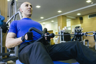 Man doing rowing exercises with low pulley - ABZF000438