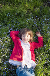 Porträt eines kleinen Mädchens mit geschlossenen Augen, das sich auf einer Wiese entspannt - LVF004826