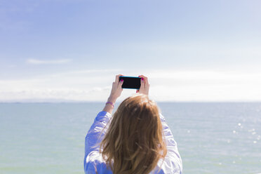 Italy, Lignano Sabbiadoro, woman with smartphone, selfie - BOYF000306