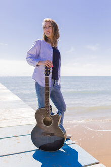 Junge Frau steht mit Gitarre auf dem Steg - BOYF000328