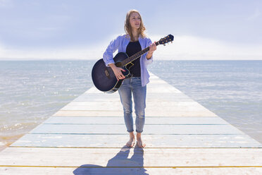 Young woman with guitar on jetty - BOYF000329