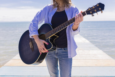 Young woman with guitar on jetty - BOYF000331