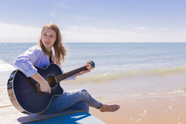 Gitarre spielende Frau auf dem Bootssteg - BOYF000336