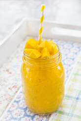 Glass of mango smoothie garnished with diced mango - LVF004839