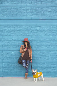 Frau mit ihrer französischen Bulldogge vor einer blauen Wand - RTBF000169