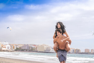 Spanien, Teneriffa, junger Mann, der seine Freundin Huckepack nimmt - SIPF000416