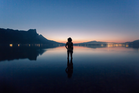 Austria, Lake Mondsee, Rear view of nude man standing in water stock photo