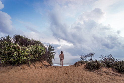 Sri Lanka, Arugam Bay, Rear view of nude man standing on beach - WV000756