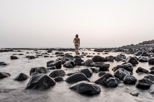 Lanzarote, Rear view of nude man standing on Playa de Janubio - WV000768
