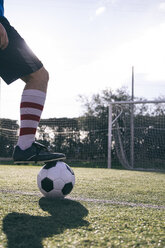 Beine eines Fußballspielers mit Ball auf dem Fußballplatz - ABZF000449