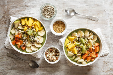 Smoothie Bowl mit verschiedenen Früchten, Mango, Papaya, Kiwi, Banane und Birne und Toppings, Leinsamen, Sonnenblumenkernen und Nüssen - EVGF002933