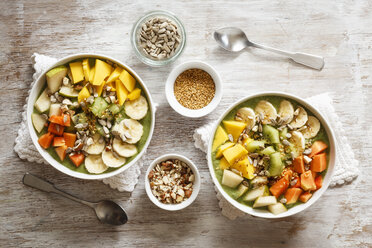 Smoothie bowl with different fruits, mango, papaya, kiwi, banana and pear and toppings, lineseeds, sunflower-seeds and nuts - EVGF002933