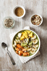 Smoothie Bowl mit verschiedenen Früchten, Mango, Papaya, Kiwi, Banane und Birne und Toppings, Leinsamen, Sonnenblumenkernen und Nüssen - EVGF002936