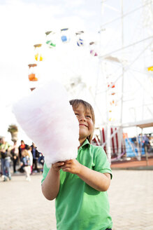 Glücklicher kleiner Junge mit Zuckerwatte auf dem Jahrmarkt - VABF000479