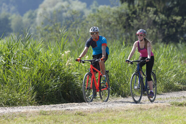 Man and teenage girl on a bicycle tour with trekking bikes - DSF000646