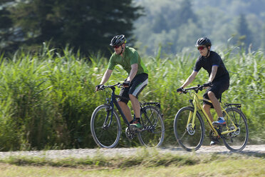 Man and teenage boy on a bicycle tour with trekking bikes - DSF000647