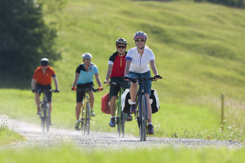 Vier Personen auf einer Fahrradtour mit Trekkingrädern, lizenzfreies Stockfoto