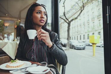 Porträt einer jungen Frau, die in einem Café sitzt und Kaffee trinkt - ZEDF000086