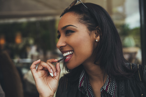 Portrait of smiling young woman eating chocolate in a cafe stock photo