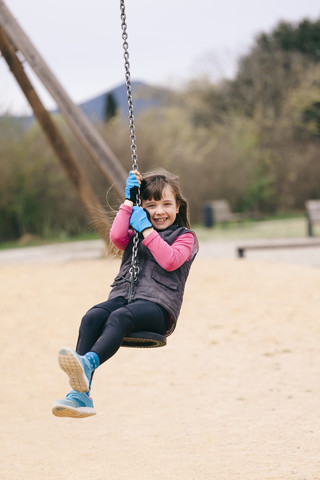 Happy girl on a swing stock photo