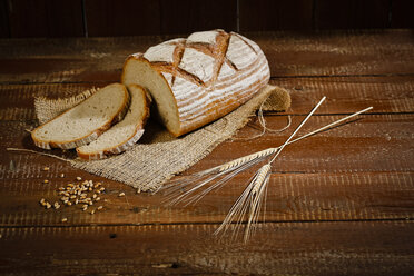 Brown bread on jute and baking paper, slices, spikes - MAEF011458