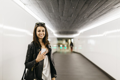 Porträt einer lächelnden jungen Frau in einem Tunnel, lizenzfreies Stockfoto